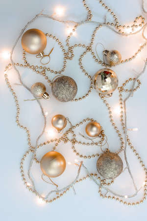Christmas holidays composition, top view of gold Christmas decorations and garland with lights on a yellow background with copy space for text. Blur. Flat lay. Winter, postcard templateの写真素材