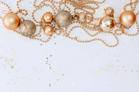 Christmas holidays composition, top view of gold Christmas decorations and garland with lights on a yellow background with copy space for text. Blur. Flat lay. Winter, postcard templateの写真素材