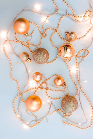 Christmas holidays composition, top view of gold Christmas decorations and garland with lights on a yellow background with copy space for text. Blur. Flat lay. Winter, postcard templateの写真素材