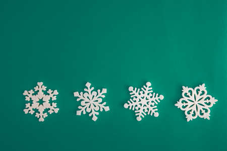 Christmas holidays composition, top view white snowflakes decoration on green and aquamarine background with copy space for text. Flat lay. Winter, postcard templateの写真素材