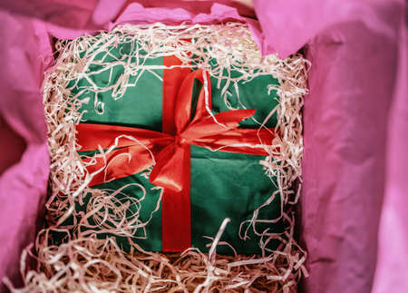 green gift box hidden in a box with shavings.の写真素材