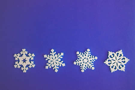 Christmas holidays composition, top view white snowflakes decoration on purple-lilac background with copy space for text. Flat lay. Winter, postcard templateの写真素材