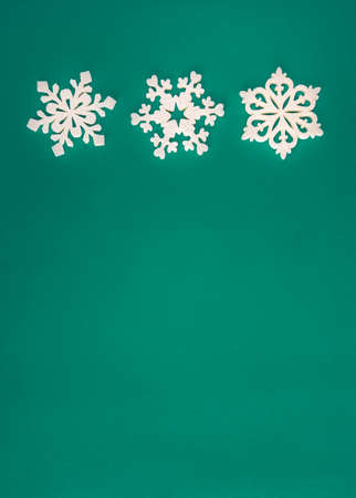 Christmas holidays composition, top view white snowflakes decoration on green and aquamarine background with copy space for text. Flat lay. Winter, postcard templateの写真素材