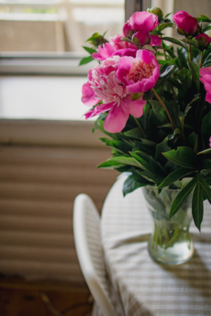 bouquet of pink peonies in a vase on the tableの写真素材