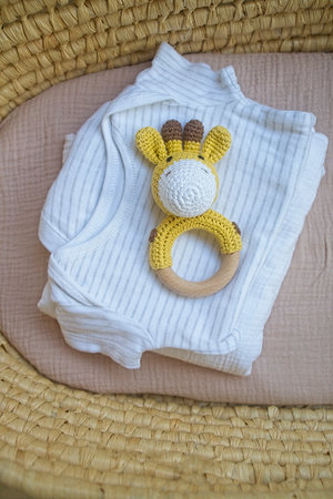 basket there are things for the baby and wooden and knitted toys-rattles. Natural natural minimalistic style. View from aboveの写真素材