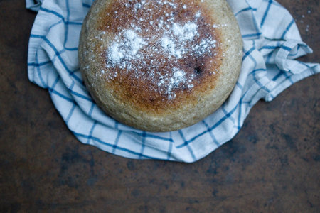 Home cooked round bread, on a dark background. View from aboveの写真素材