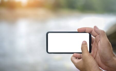 Man holding smart phone with blurred nature background