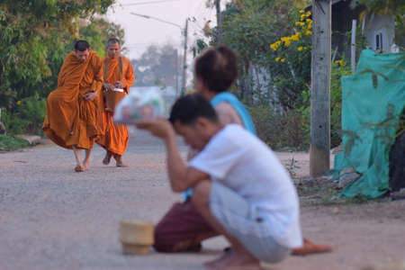Kalasin, Thailand - February 22, 2021 : People were waiting to give food to the monks in the morning and are paying respect to monksのeditorial素材