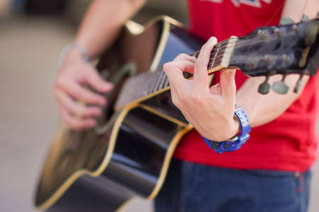 A male hand close up playing the guitar, Musician