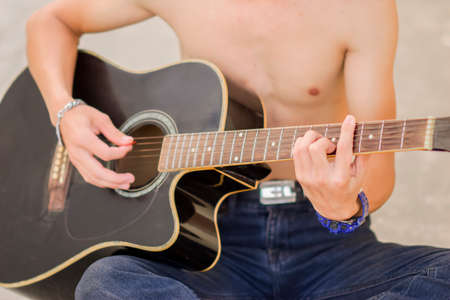 A male hand close up playing the guitar, Musician