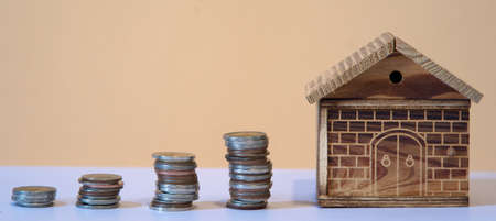Coins in a row with wooden house, financial growth and saving money concept, panoramic banner for webの写真素材