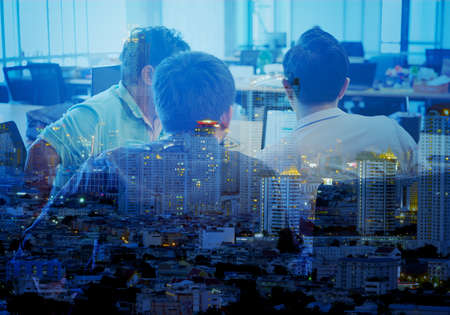 double exposure of back view business men are meeting in the office and city night view, Business people are planning business conceptの写真素材