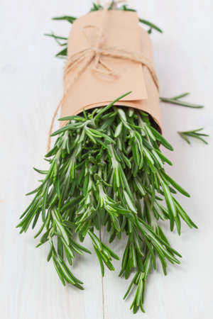 bunch of fresh rosemary and chives on wooden tableの写真素材