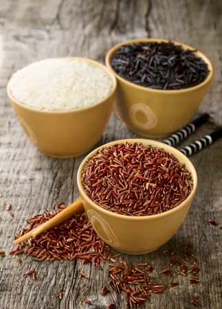 rice - red, white and wild in a bowls with  chopsticks on wooden tableの写真素材