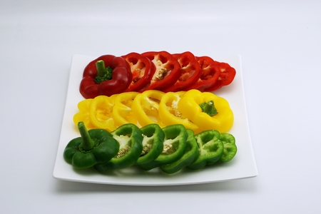 isolated set of slightly cut sweet pepper on dish