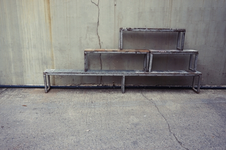 stack of wood bench with the old concrete wall background
