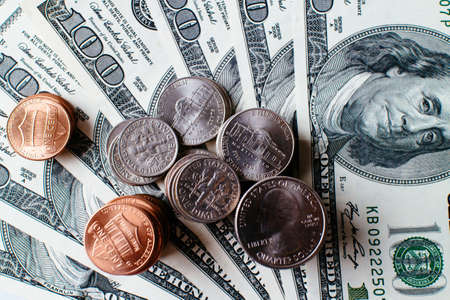 Pile of 100 US dollar banknotes and coins.の写真素材