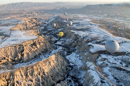 Hot air balloons fly over Cappadocia in winter, Goreme, Turkey.の写真素材