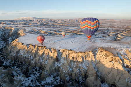 Hot air balloons fly over Cappadocia in winter, Goreme, Turkey.の写真素材
