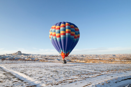 Hot air balloons fly over Cappadocia in winter, Goreme, Turkey.の写真素材