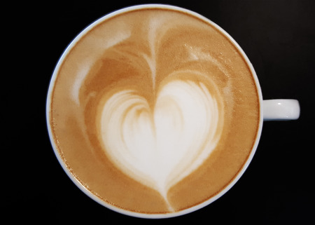 Heart shape coffee foam  isolated on black background.