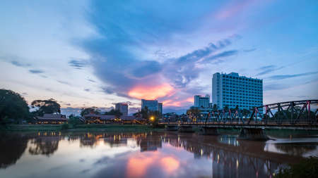 The historical iron bridge at Chiangmai city skyline at Ping river at dusk. Chiangmai , Thaland. Long exposure photograph.の写真素材