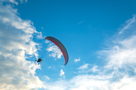 A flying paramotor on a vibrant sky with cloud. Extreme sport.の写真素材
