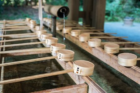 Traditional Japanese ladle for purification in a cleansing well in a peaceful Japanese temple.