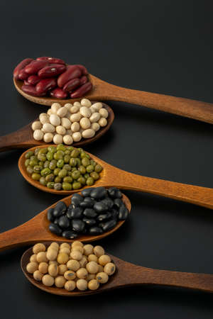 Collection of whole grains seeds isolated on black background. Healthy diet raw ingredients.の写真素材