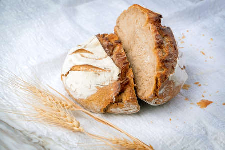 Fresh sourdough bread with a coffee mug on white fabric. Healthy eating breakfast.