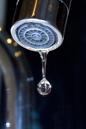 Water drop falling from a tapの写真素材
