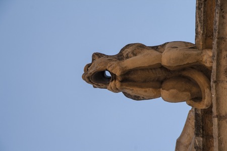 A gargoyle is a carved or formed grotesque with a spout designed to convey water from a roof and away from the side of a building,の写真素材