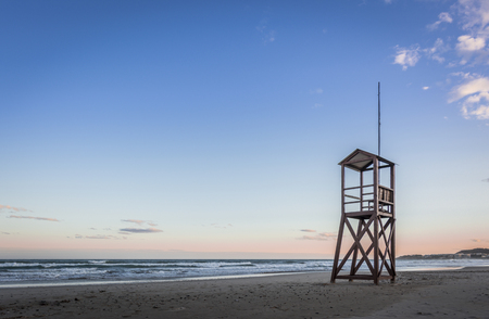 Beach sunrise with lifeguard wooden towerの写真素材