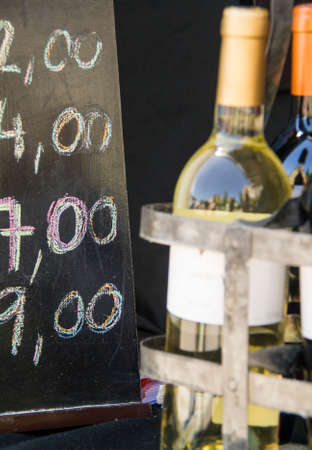 Wine bottles and chalk board with pricesの写真素材