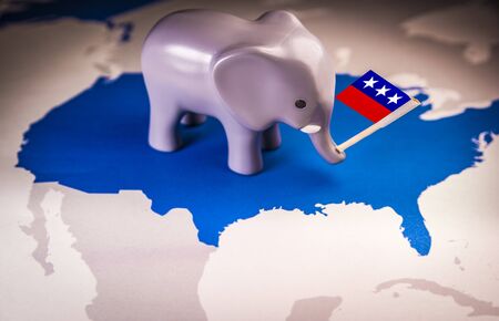 Toy elephant holding a Republican party flag over a USA mapの写真素材