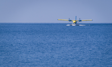 Private seaplane or hydroplane landing in the ocean lagoon in one of the Maldives islands.の写真素材