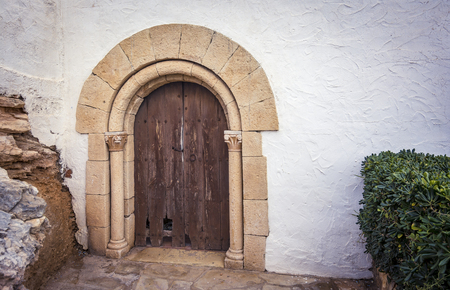 Ancient wooden door and stone gate of a small hermitage in Roc de Sant Gaieta, Spainの写真素材