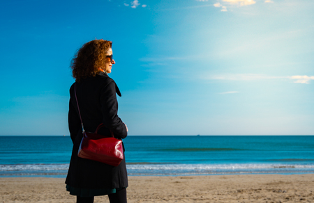 Women wearing autum or winter clothes looking at the sea. Copy space.の写真素材