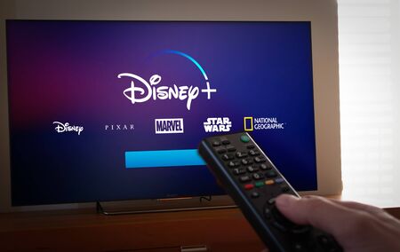 Barcelona, Spain. January 2019: Man holds a remote control With Netflix, HBO and the new Disney  logos on TV screenのeditorial素材