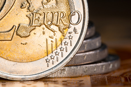 Two euro coins over euro banknotes. Currency of the European Union.