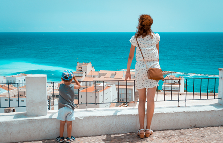 Tourist woman and son looking at the mediterranean sea in Altea, Alicante, Spainの写真素材