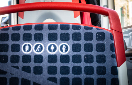 Close up of round icon priority seat for elderly, pregnant or disabled people on a bus seat in...