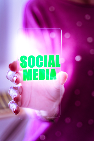 Close up of woman hand holding and showing transparent and futuristic smartphone at officeの写真素材