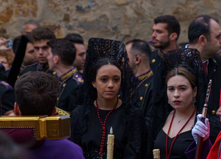 Girls in Easter procession with a black lace mantilla, a traditional Spanish veil worn by the women
