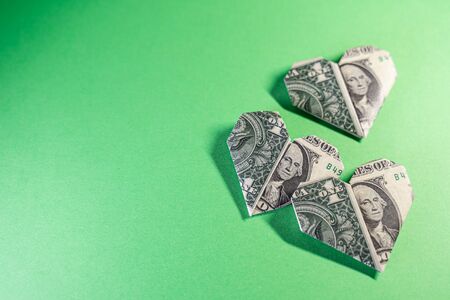 One Dollar origami hearts on a green backgroundの写真素材