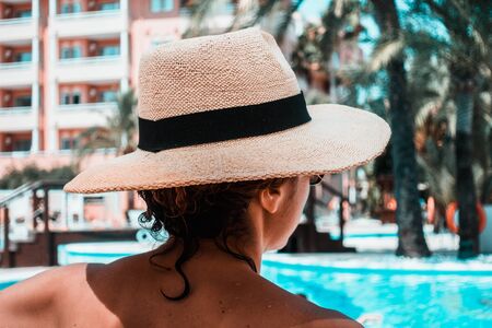 Woman with sunhat relaxing in swimming pool at spa resort.の写真素材