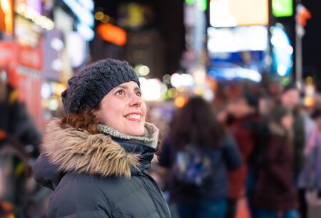 Amazed woman looking at the lights and the crowd in times squareの写真素材