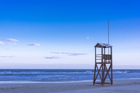 Classic Blue beach sunrise with lifeguard wooden towerの写真素材
