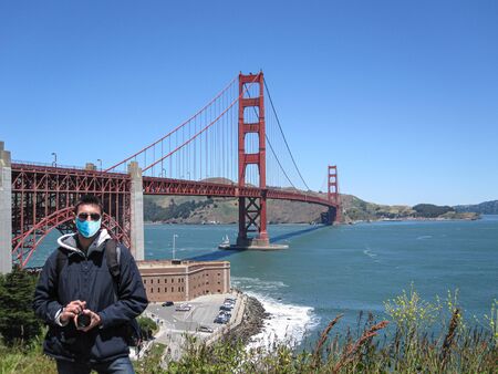 Man wearing surgical mask in San Francisco, with the Golden Gate on the Backgroundの写真素材