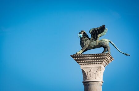 Venices symbol, the winged lion statue with a surgical maskの写真素材